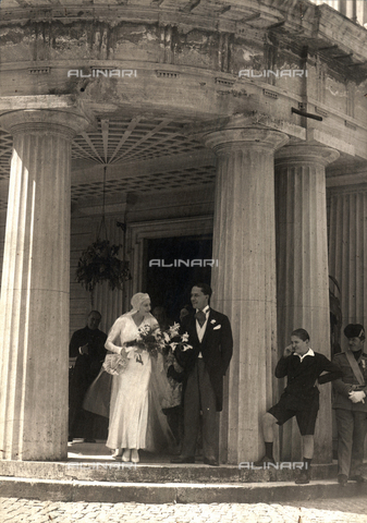 BAA-F-000038-0000 - Edda Mussolini e Galeazzo Ciano nel giorno delle nozze. Gli sposi, rispettivamente in lungo abito bianco e tight, sorridono all'uscita di Villa Torlonia - Data dello scatto: 1930 - Archivi Alinari, Firenze