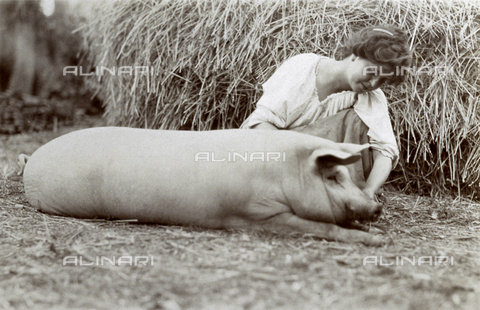 BAQ-F-001139-0000 - Giovane contadina inginocchiata accanto a un piccolo suino. - Data dello scatto: 1907 - 1913 ca. - Archivi Alinari, Firenze