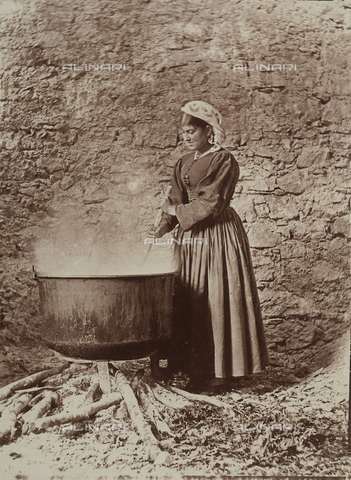 BAQ-F-001296-0000 - Donna ritratta accanto a un grande contenitore sul fuoco a Scanno - Data dello scatto: 1910 - Archivi Alinari, Firenze