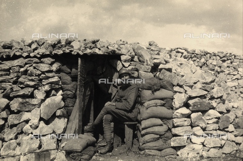 BCA-F-000004-0000 - Un soldato seduto davanti all'ingresso di un bunker durante la Prima Guerra Mondiale. - Data dello scatto: 1915 - 1918 ca. - Archivi Alinari, Firenze