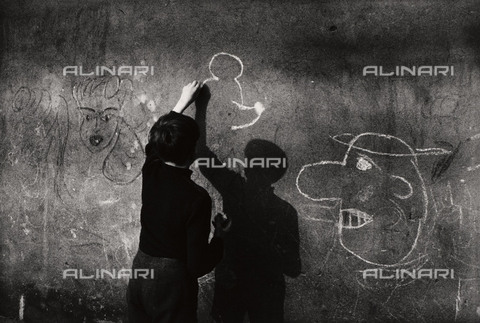 BPK-S-AA3002-6453 - Muro di Berlino: un ragazzo disegna Topolino sul muro - Data dello scatto: 1963 - Kunstbibliothek, SMB / Bernard Larsson / BPK/Archivi Alinari