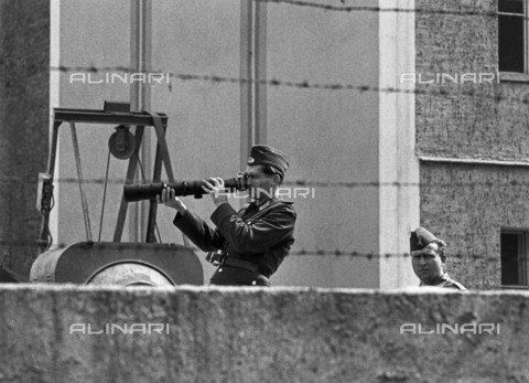 BPK-S-AA7013-6219 - Muro di Berlino: soldato della GDR fotografato in una postazione di controllo sul muro - Klaus Lehnartz / BPK/Archivi Alinari