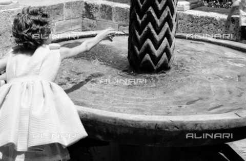 BVA-S-S10010-0011 - Bambina fotografata davanti alla fontana di re Guglielmo II nel chiostro del Duomo di Monreale - Data dello scatto: 1960-1961 - Archivi Alinari, Firenze