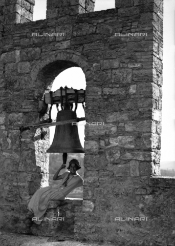 CAD-S-080001-0001 - Portrait of a young woman near the bell of the Rocca di Staggia Senese castle - Date of photography: 14/09/1924 - Alinari Archives, Florence