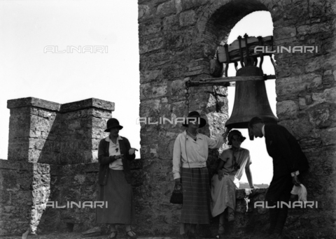 CAD-S-080001-0002 - Portrait of a young woman near the bell of the Rocca di Staggia Senese castle - Date of photography: 14/09/1924 - Alinari Archives, Florence