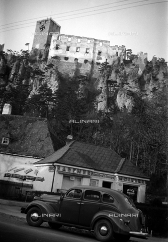 CAD-S-290047-0009 - View of castle ruins near road with parked car near a cafe - Date of photography: 1930 ca - Alinari Archives, Florence