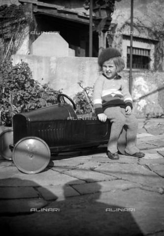 CAD-S-290048-0001 - Ritratto di bambino seduto su un'automobile giocattolo - Data dello scatto: 1920-1930 ca - Archivi Alinari, Firenze