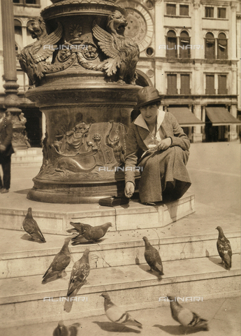 CMA-F-001180-0000 - Vittoria Castagneri, wife of photographer Mario, photographed in Piazza San Marco in Veneza, while feeding the pigeons - Date of photography: 1915 ca. - Alinari Archives, Florence