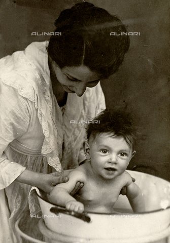 CMA-F-001181-0000 - Vittoria Castagneri as she bathes her son Giampiero - Date of photography: 1917 ca. - Alinari Archives, Florence