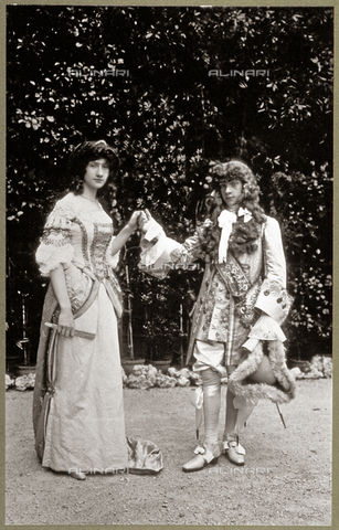 FBQ-F-001870-0000 - Full-length portrait of a young couple in a garden in late seventeenth century costume. The two figures are holding hands and dancing a minuet - Date of photography: 1895 - 1912 - Alinari Archives, Florence