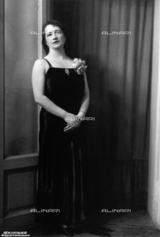 FBQ-S-000457-0005 - Full-length portrait of a woman in evening gown. A hydrangea flower is pinned to her dress and she is wearing a necklace - Date of photography: 1920 -1930 ca. - Alinari Archives, Florence