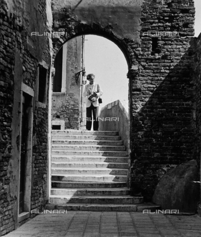 LFA-F-000062-0000 - "Leiss in Venice". A portrait of the photographer Feruccio Leiss holding a camera, standing in a Venetian street - Date of photography: 1955 - Alinari Archives, Florence