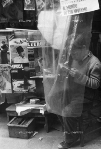 LFA-F-000086-0000 - "The world in which we live" a boy reading a small book in front of a newstand, Venice - Date of photography: 1950 ca. - Alinari Archives, Florence