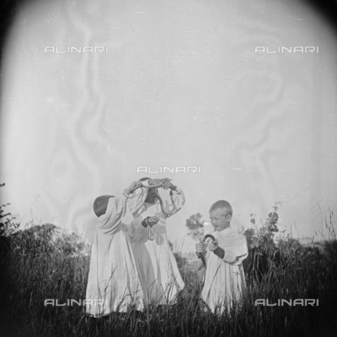 MFA-S-0SN400-000S - Three children in traditional clothes playing with some serpents in the countryside - Date of photography: 1900 ca. - Alinari Archives, Florence