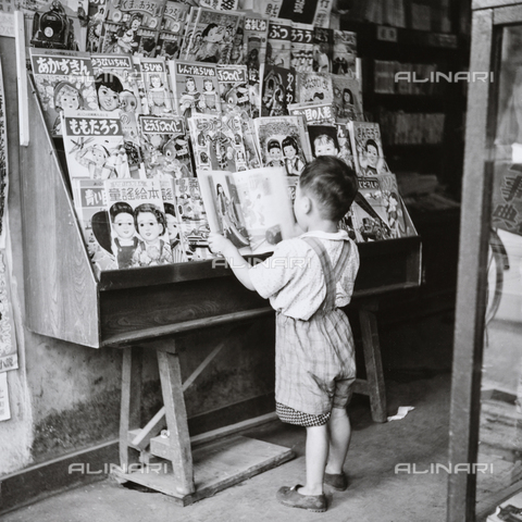 MFV-F-JBN320-0000 - Bambino che sfoglia fumetti - Data dello scatto: 1953-1963 - Foto di Fosco Maraini/Proprietà Gabinetto Vieusseux © Archivi Alinari