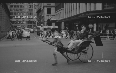 MFV-S-V00133-0233 - Persona su risciò nelle strade di Hong Kong - Data dello scatto: 1962-1963 - Foto di Fosco Maraini/Proprietà Gabinetto Vieusseux © Archivi Alinari