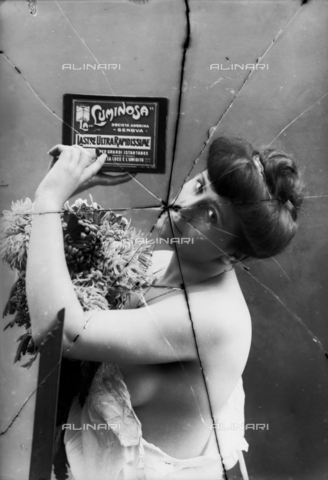 NVM-F-003213-0000 - Female Portrait  in skimpy clothes. The woman shows an advertisement of Società Anonima "La Luminosa" for  plates high speed - Date of photography: 1900-1910 - Alinari Archives, Florence