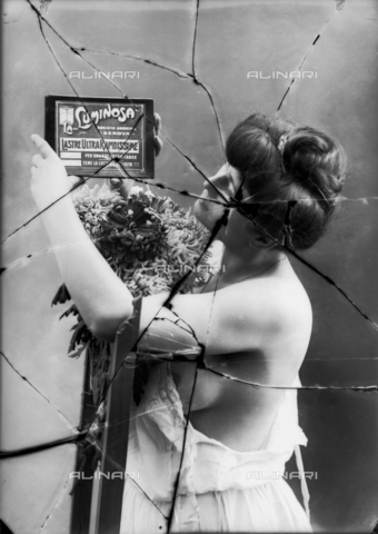 NVM-F-003214-0000 - Female Portrait  in skimpy clothes. The woman shows an advertisement of Società Anonima "La Luminosa" for  plates high speed - Date of photography: 1900-1910 - Alinari Archives, Florence