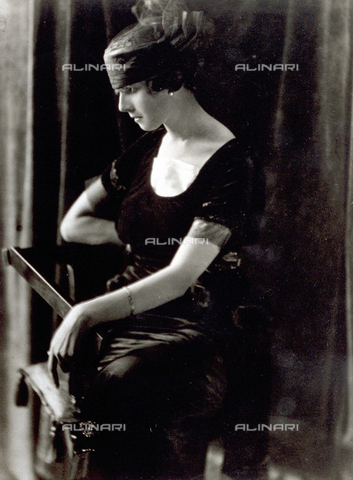 PDC-F-000574-0000 - Ritratto di profilo, di giovane donna in abito da sera degli anni '20, seduta su una sedia, con i capelli raccolti in una fascia - Data dello scatto: 1920 ca - Archivi Alinari, Firenze