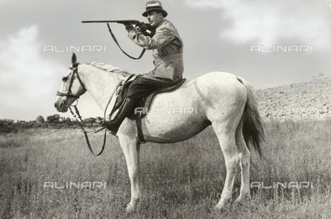 TCI-S-000254-AR10 - Hunter with rifle at the ready on horseback to be able to move quickly to catch any wounded boar and finish it off - Date of photography: 1940 ca. - Touring Club Italiano/Alinari Archives Management