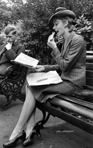 TOP-F-851179-0000 - An employee eats a sandwich while reading the newspaper during the lunch break - TopFoto / Alinari Archives