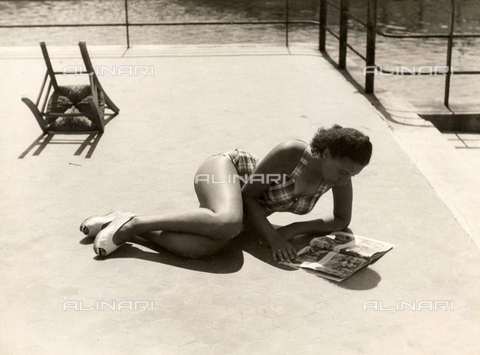 VZA-F-000271-0000 - A girl wears a swimming suit while reading a magazine and tanning - Date of photography: 1940 ca. - Alinari Archives, Florence