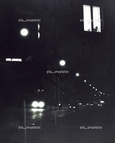 VZA-F-000299-0000 - "Window in the night". View of a street at night with street lights and cars; It is also known the luminous sign of a motel and a lighted window - Date of photography: 1980 - Alinari Archives, Florence