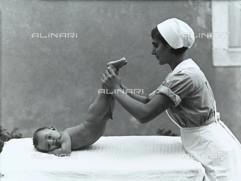 WWA-F-001957-0000 - Infermiera con neonato, durante un esercizio, posano per il libro "La ginnastica del lattante" di Eugenio Paulin - Data dello scatto: 1934 ca. - Archivi Alinari, Firenze